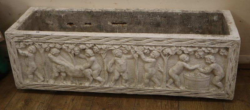 A rectangular reconstituted stone garden planter, decorated with bacchic cherubs, W.100cm, D.29cm, H.34cm